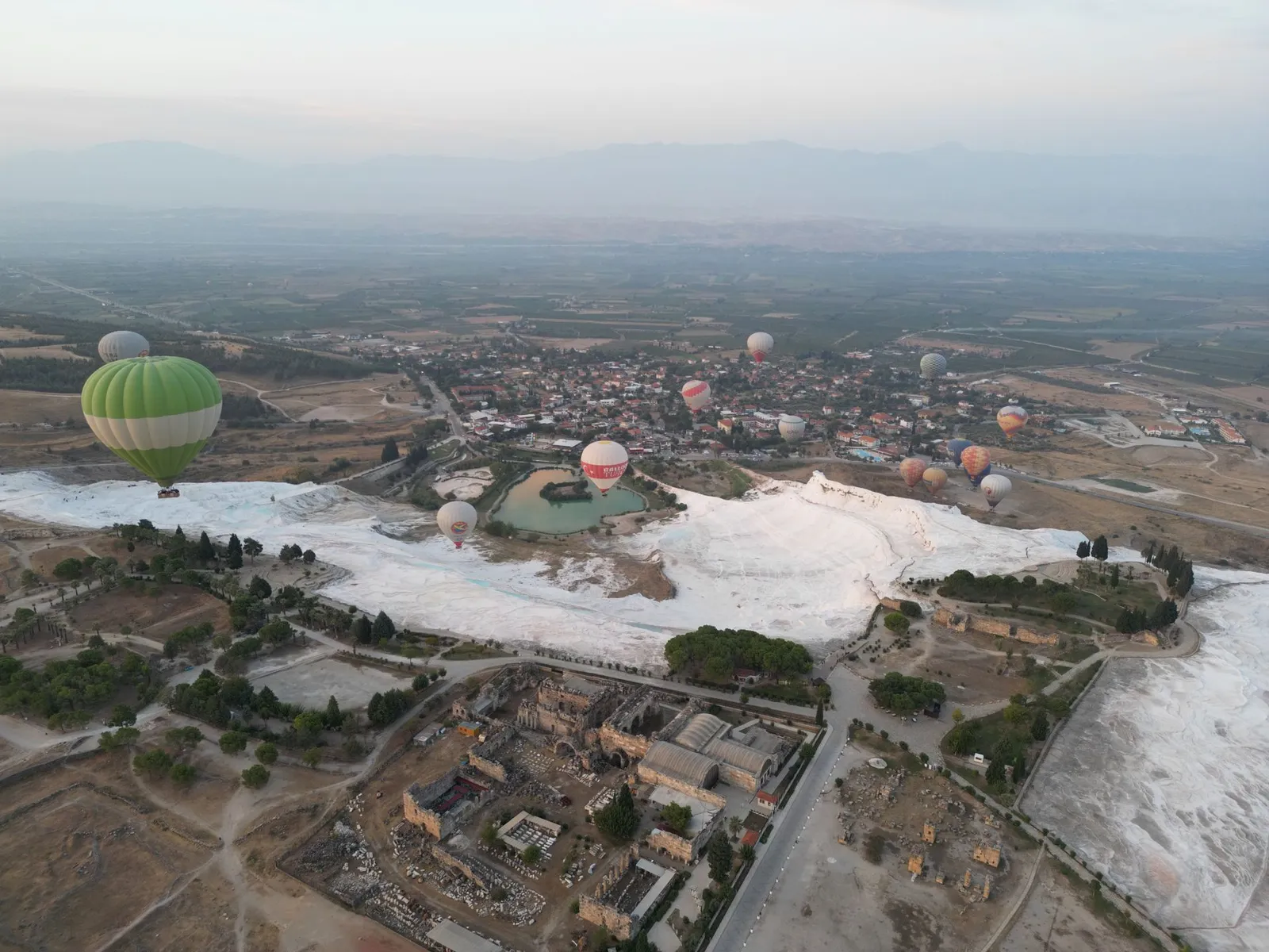 Hot-air balloons over the travertines and Hierapolis at Pamukkale