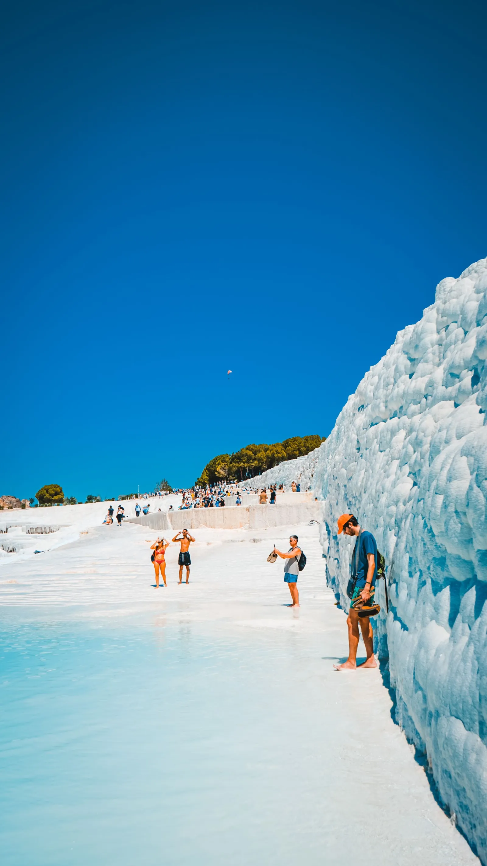 Visitors walking on the travertine terrace pools at Pamukkale