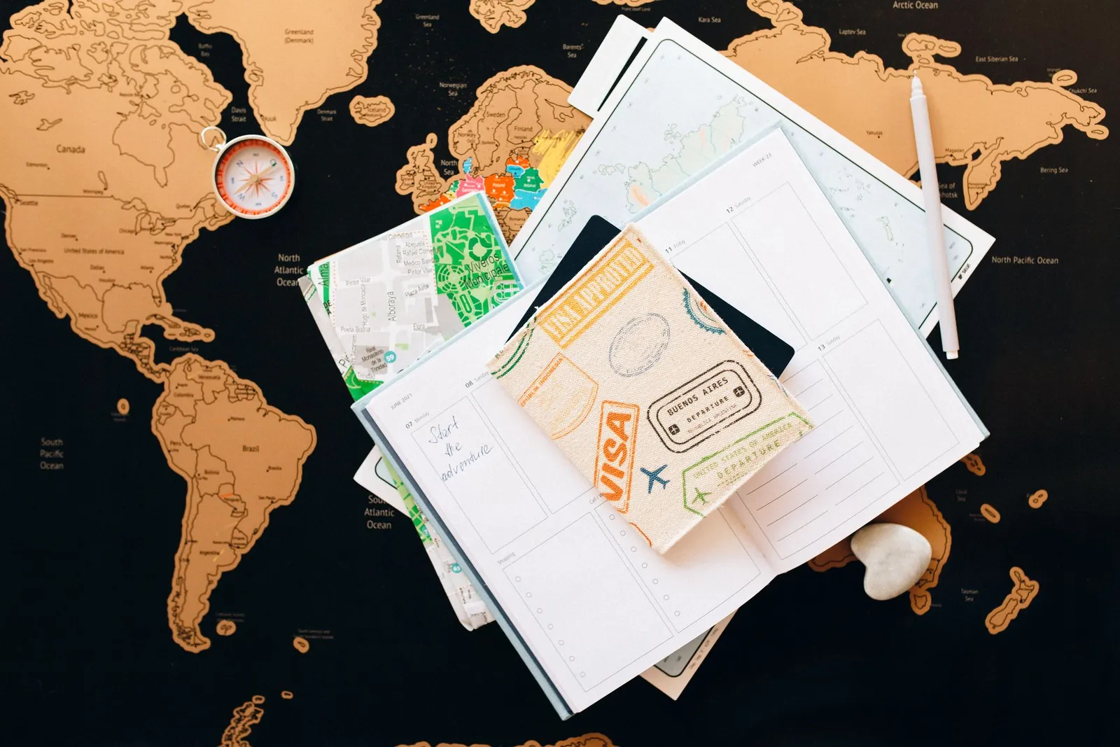Travel planner, map and compass laid out for trip planning